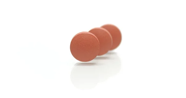 Tre pillole marroni in piedi in dissolvenza riga — Foto Stock