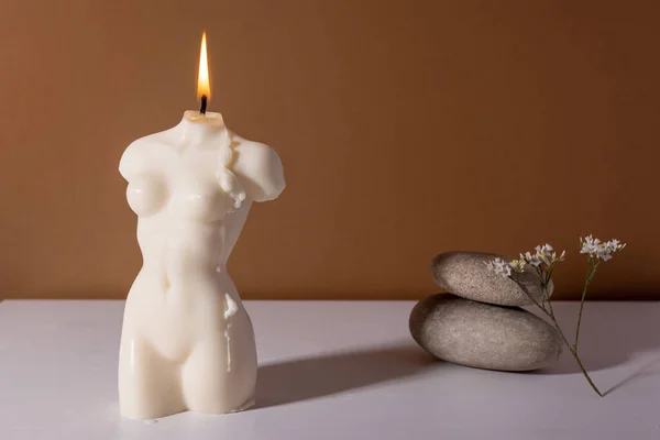 Candle in woman torso shape in brown interior with stone and dried flowers, autumn atmosphere — Stock Photo, Image
