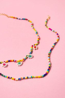 Pembe arka planda renkli pastel aksesuarlar, yakın plan, modaya uygun geçmişler.