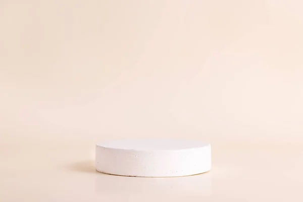 Beyaz beton daire bej arka planda kaideyi şekillendirdi. Ürünler için podyum modelleme geçmişi. Reklam şablonu. Taş platform. Soyut geometrik