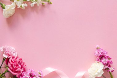 Yaz ve bahar pembe çerçevesi güzel çiçeklerle süslenmiş ve metin için boş alan var. Pembe güller ve beyaz karanfil