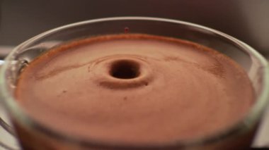 Kahve makinesinden kahve dolu fincana yavaşça 4k makro görüntülü bir espresso damlası. 