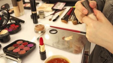 Profesyonel makyöz kadın palette makyaj kremi karıştırıyor..