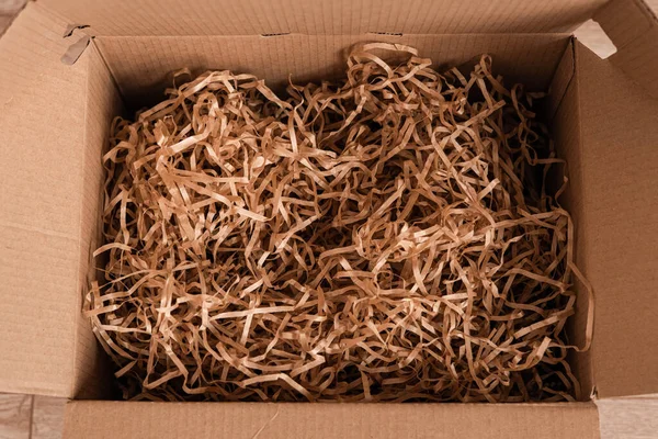 Moving day, box with paper material.Eco material for packaging goods, things, fragile items. Decorative wood shavings — 图库照片