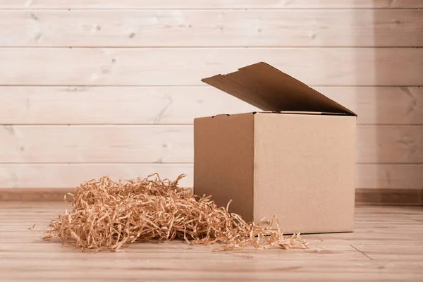 Taşınma günü, kağıt maddeyle dolu bir kutu. Paketleme malzemeleri, eşyalar, kırılgan eşyalar için eko malzeme. Dekoratif ahşap talaşı