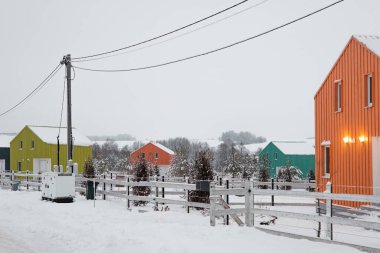 İskandinav tarzında modern ahşap ev. Farklı renkte, köyde kış günü.
