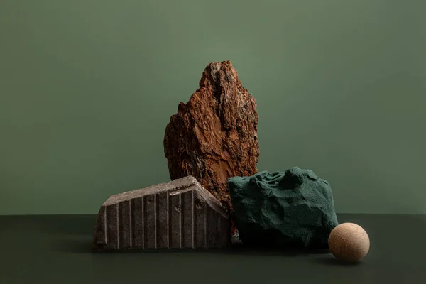 Yeşil arka plan üzerine ahşap, ağaç kabuğu ve kağıttan yaratılan kozmetik ürünleri için doğal arka plan podyumu. Yaratıcı modern natürmort