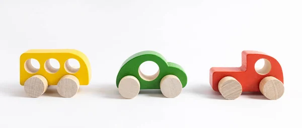 Coche de juguete de madera en estilo de dibujos animados sobre fondo blanco. Fondo colorido y transporte, juguetes para niños ecológicos Montessori . Fotos de stock libres de derechos
