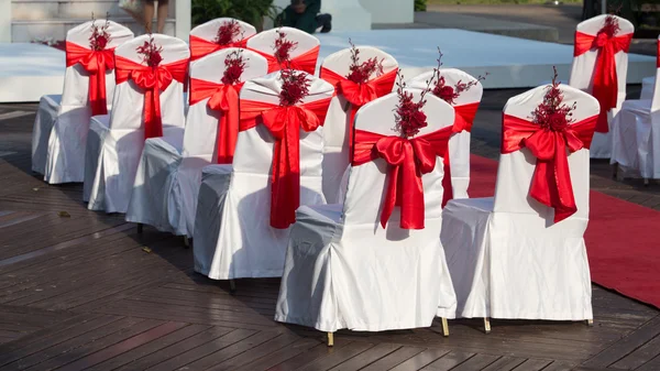 Cadeiras de casamento decoradas com rosas vermelhas — Fotografia de Stock