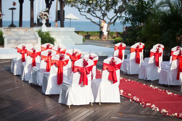 Bruiloft stoelen versierd met rode rozen — Stockfoto
