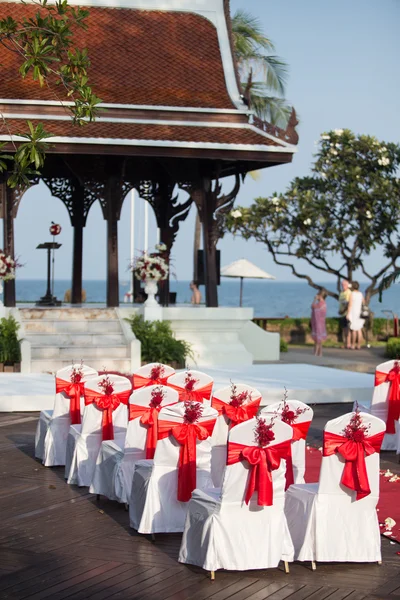 Cadeiras de casamento decoradas com rosas vermelhas — Fotografia de Stock