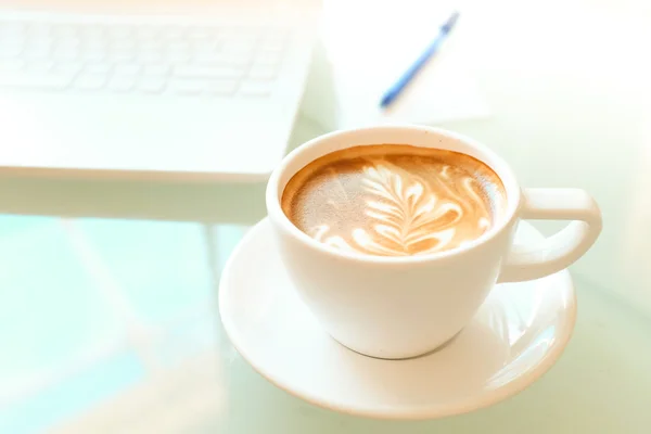 A cup of coffee and a laptop — Stock Photo, Image