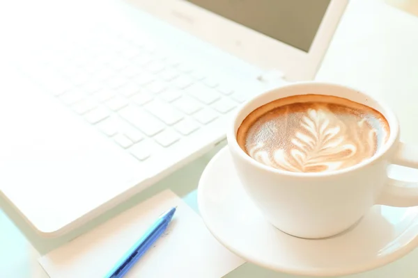 A cup of coffee and a laptop — Stock Photo, Image