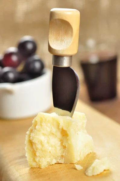 Parmesan, Trauben und Wein auf einem hölzernen Schneidebrett — Stockfoto