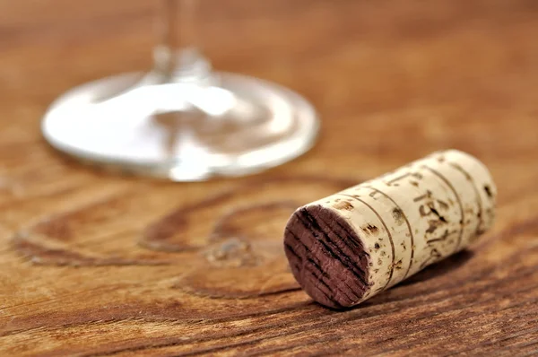 Пробка и бокал итальянского красного вина на столе из дуба — стоковое фото
