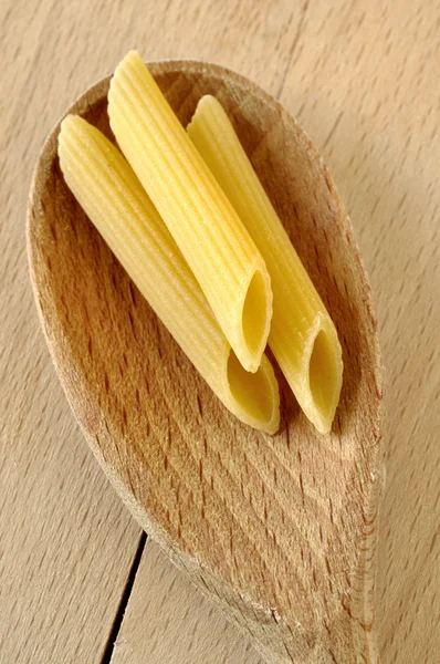 Penne on a wooden spoon — Stock Photo, Image