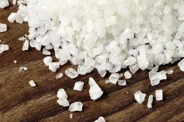 Coarse sea salt on a wooden table — Stock Photo, Image