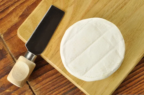 Italiaanse tomino kaas op een houten snijplank — Stockfoto