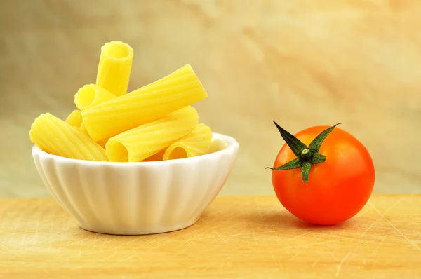 Raw tortiglioni pasta in a small bowl, selective focus — Stockfoto