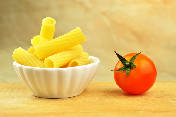 Raw tortiglioni pasta in a small bowl, selective focus — Stock Photo, Image