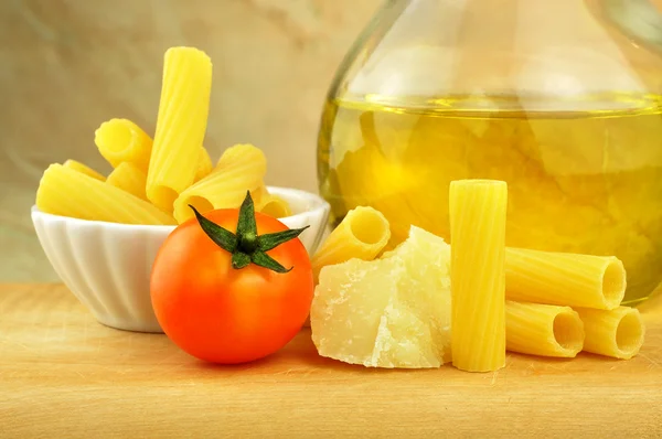 Raw tortiglioni pasta with parmesan, cherry tomato and olive oil — Stock Photo, Image