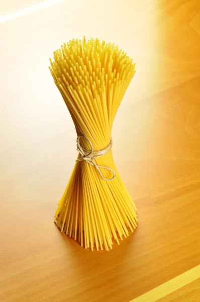 Spaghetti pasta on a wooden chopping board — Stock Photo, Image