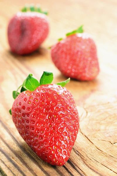 Fresas en una vieja mesa de madera — Foto de Stock