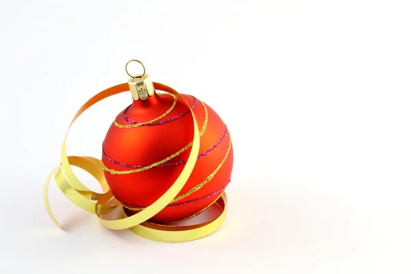 Red Christmas tree ball with curly ribbons on white background — Stock Photo, Image