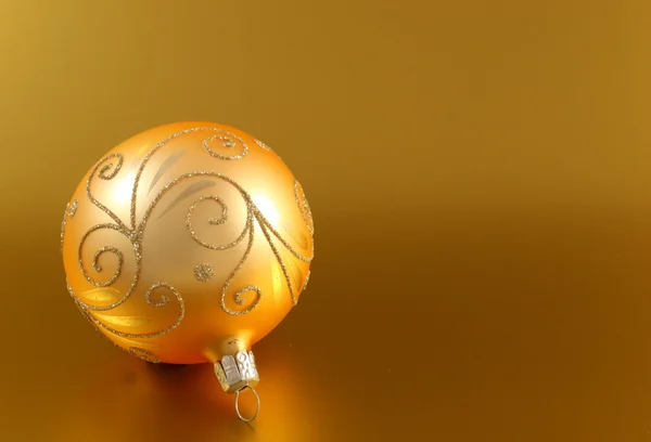 Golden christmas ball on gold background — Stock Photo, Image