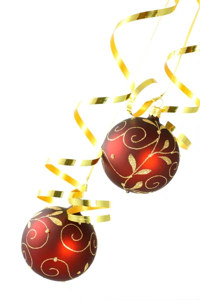 Two red Christmas tree balls with curly ribbons on white background — Stock Photo, Image