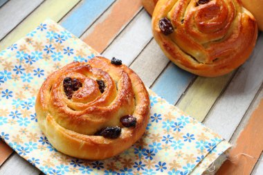 taze tatlı girdap üzümlü çörek üzerinde renkli ahşap tablo