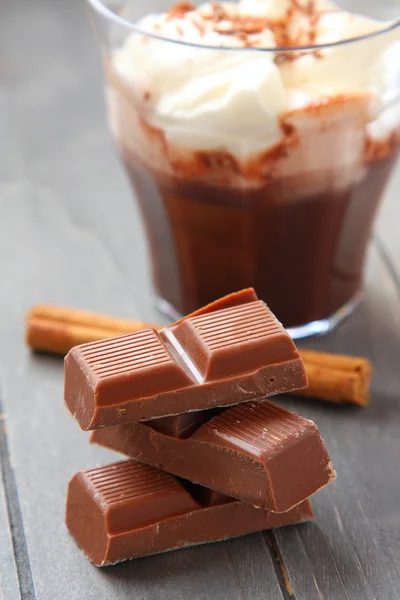 Chocolate pieces with chocolate milkshake and cinnamon stick — Stock Photo, Image