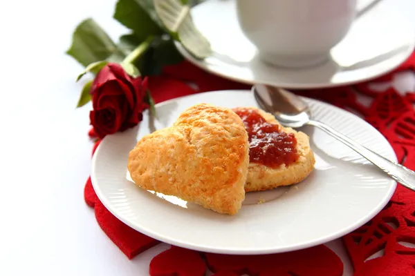 Heart shaped scones with strawberry jam and a cup of tea — Stock Photo, Image