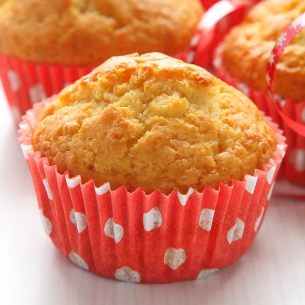 Muffins em copos vermelhos no fundo branco — Fotografia de Stock