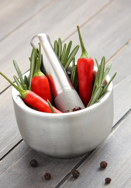 Čerstvý rozmarýn herb a červenou papriku v kovových Malty s tloučkem — Stock fotografie