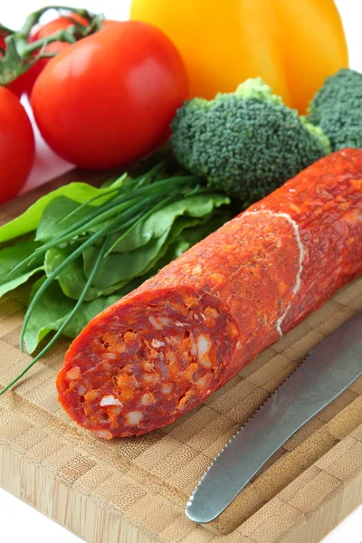 Salsiccia chorizo spagnola con verdure su una tavola di legno — Foto Stock