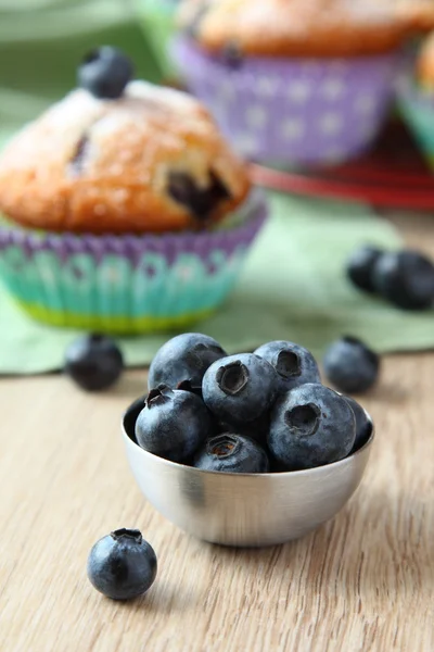 Fresh blueberries in metal bowl and blueberry muffin — Stock Photo, Image
