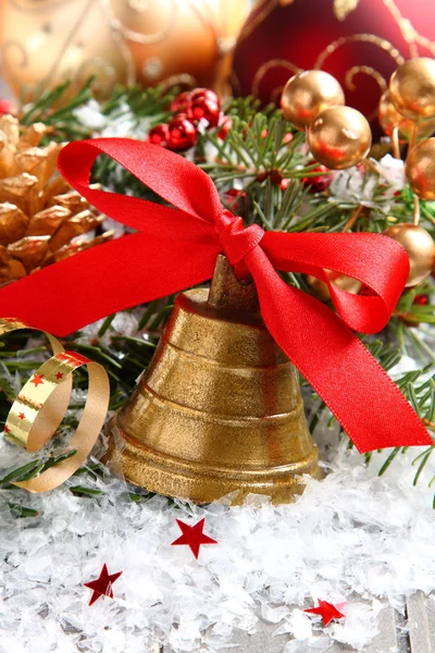 Golden bell with red ribbon bow and christmas decoration — Stock Photo, Image