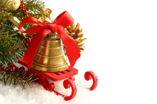 Christmas composition with sleigh and golden bell over white — Stock Photo, Image