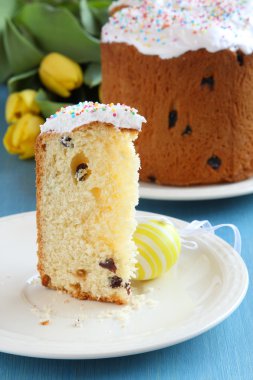 Paskalya ekmek ile renkli yumurta ve mavi ahşap zemin üzerine Sarı laleler