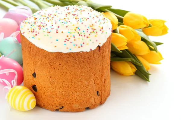 Pasen brood, kleurrijke eieren en gele tulpen op witte achtergrond — Stockfoto