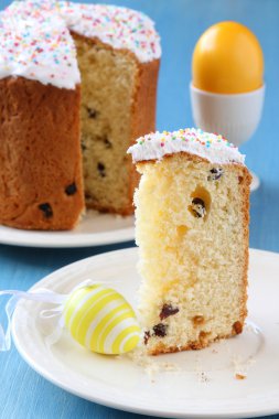 Paskalya ekmek ile renkli yumurta ve mavi ahşap zemin üzerine Sarı laleler