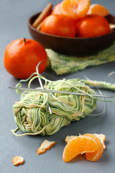Boule de fil avec aiguille à tricoter et mandarines fraîches sur fond gris — Photo