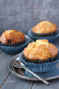 rustik ahşap zemin üzerinde mavi paketleyicileri üzümlü kek