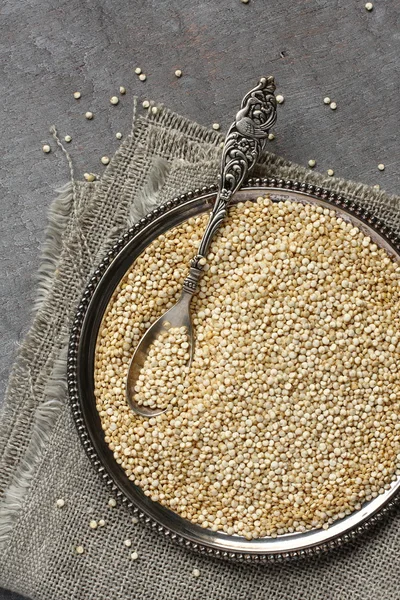Quinoa não cozida em placa de metal em fundo de madeira — Fotografia de Stock