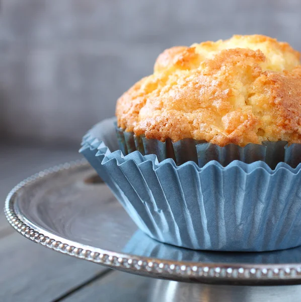 Muffin com passas em embalagens azuis em uma placa de metal — Fotografia de Stock