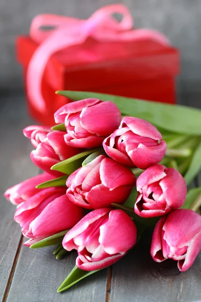 Bei tulipani rosa con scatola regalo su sfondo di legno — Foto Stock