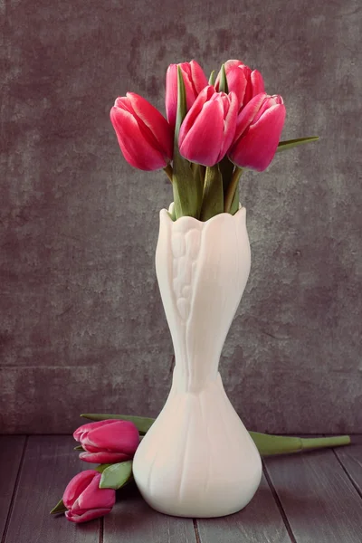 Bouquet of pink tulips in white vase on wooden background — Stock Photo, Image