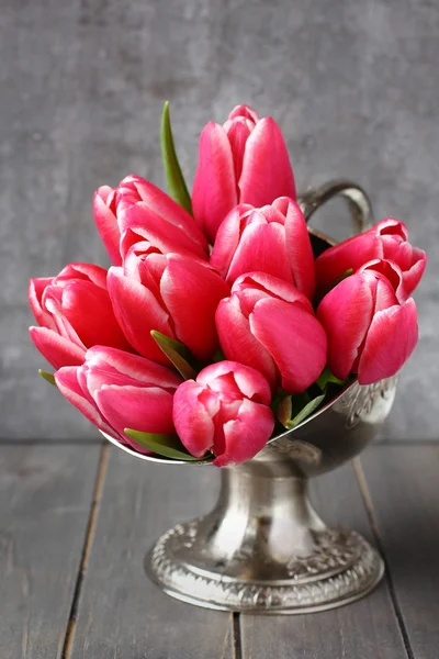 束粉红色郁金香在金属花瓶放在木制的背景 — 图库照片