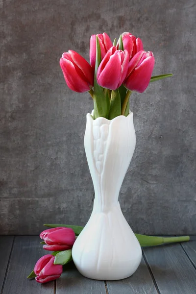 Boeket van roze tulpen in witte vaas op houten achtergrond — Stockfoto